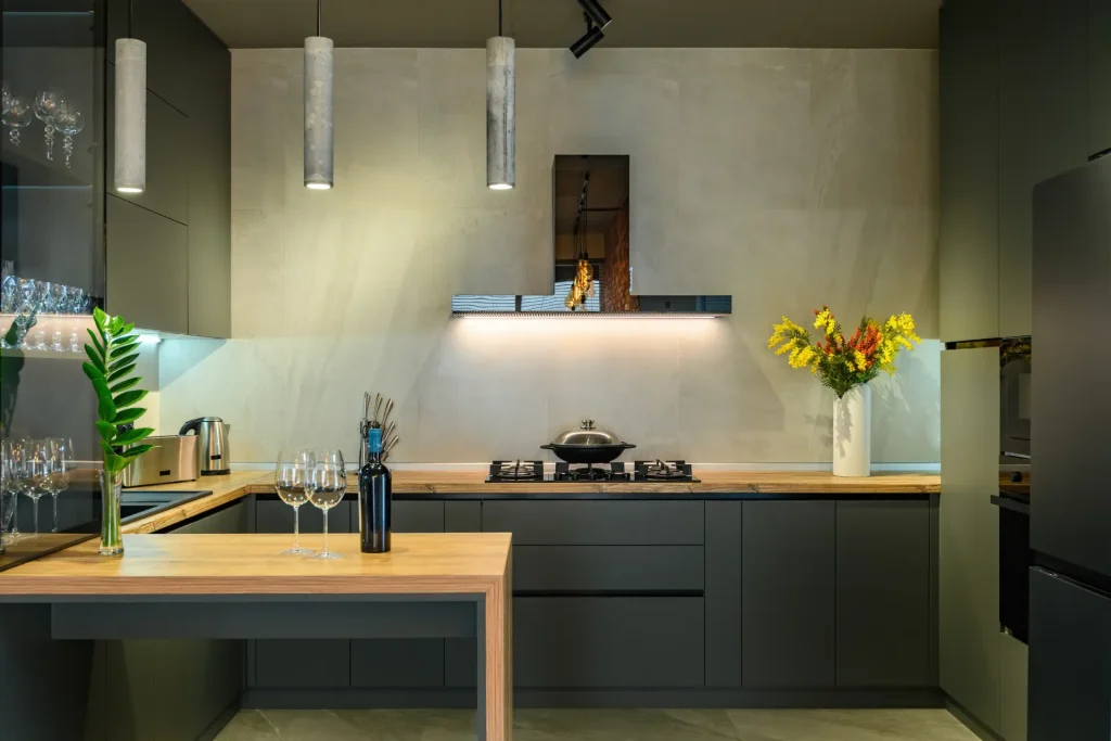 Modern kitchen installation with matte green cabinets and wood countertops